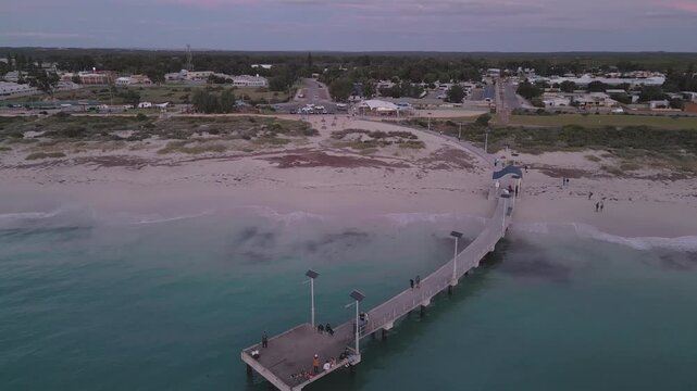 Cinematic drone footage panning towards and upwards from the Jurien Bay Jetty to reveal the remainder of the town at sunset.