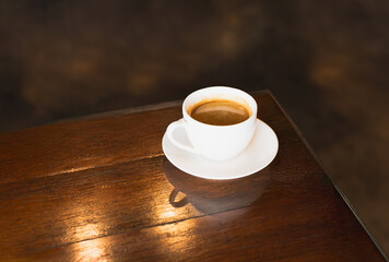 A cup of coffee on wooden table.