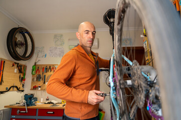 Cyclist adjusting bike in home workshop