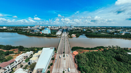 Aerial view of the vibrant city bisected by the tranquil river, where the bridge connects shores under a vast sky, Iloilo City, Western Visayas, Philippines.
