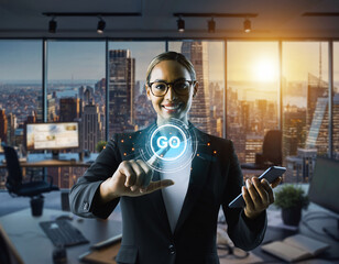 Confident businesswoman in modern office using digital interface. Go displayed, symbolizing progress, technology, innovation, and success in a global business setting.