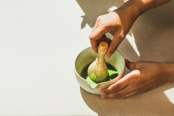 Barista preparing matcha green tea in cafe.