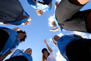 Women's football team huddling and cheering together
