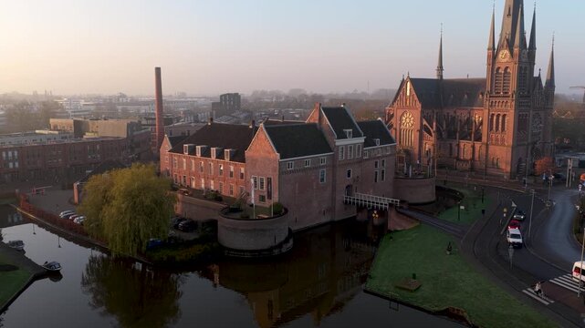 Aerial view of the historic Kasteel Woerden and Sint-Bonaventurakerk, with orange and red brick contrasting against the water, Woerden, Utrecht, Netherlands.