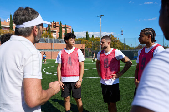 Coach talking to soccer players on field