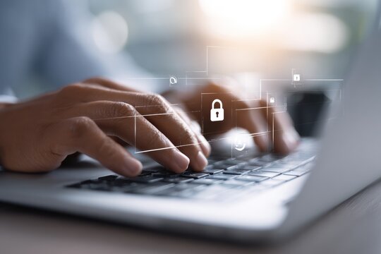 Hands typing on laptop with glowing digital security icons overhead.