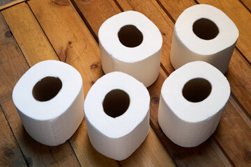 toilet paper rolls on a wooden shelf