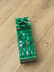 Naklejka premium Minecraft Creeper Model on Wooden Floor