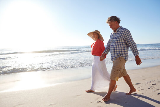 Love, trust and holding hands with couple at beach for summer vacation, romance and connection. Bonding, anniversary getaway and walk with mature man and woman outdoor for holiday, space and date