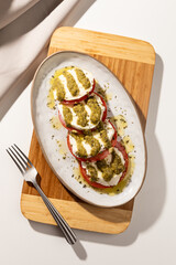 Top view of caprese salad isolated on wooden board
