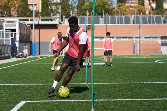 Young man practicing soccer drills on artificial turf