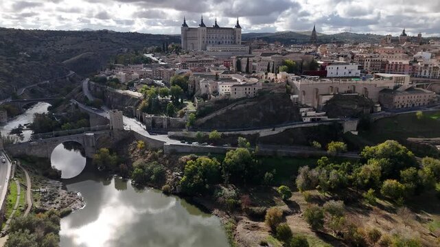 Aerial view of the iconic Alcazar fortress overlooking the Tagus River and the historic city, showcasing the blend of nature and architecture, Toledo, Castile-La Mancha, Spain.