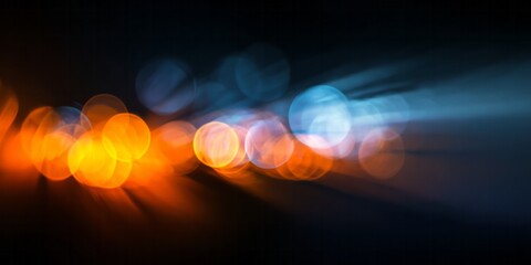 Brilliant orange and cool blue light sources blur into abstract circular shapes against a dark background
