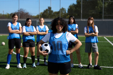 Young female soccer team posing on field
