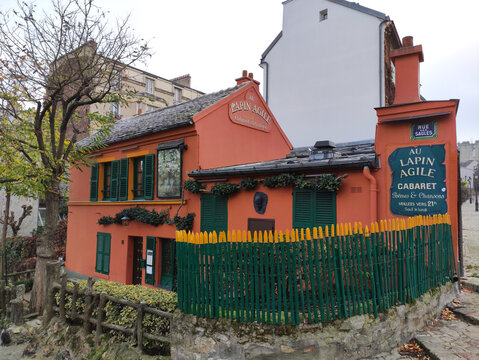 Paris, France - November 22, 2025: Au Lapin Agile cabaret in Montmartre, Paris, features vibrant orange facade and green shutters, showcasing historic charm and artistic heritage