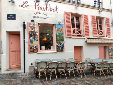 Paris, France - November 22, 2025: Le Poulbot cafe and bar in Montmartre, Paris, features charming outdoor seating with colorful murals, showcasing the vibrant atmosphere of the iconic neighborhood
