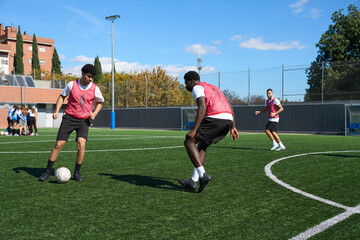 Young men training soccer on artificial pitch