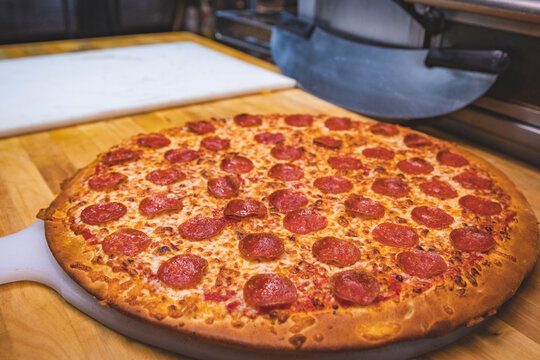 Pepperoni Pizza on Cutting Board, Pizza Knife in Background