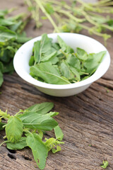 Fresh holy basil leaves on rustic wood
