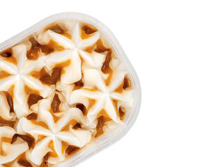 Ice cream with vanilla-caramel flavor in a plastic container. Frozen dessert in a tub, creamy texture.