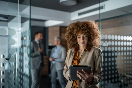 Businesswoman standing in office lobby using tablet