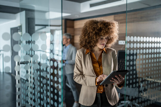 Businesswoman standing in modern office using digital tablet