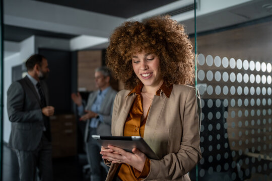 Smiling businesswoman using tablet in modern office