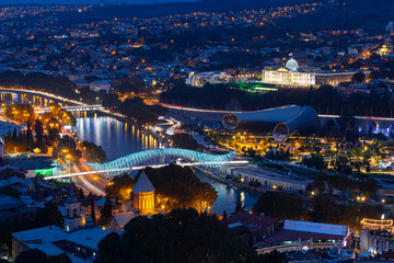 Naklejka premium Tbilisi Night Cityscape View With Peace Bridge And Mtkvari River