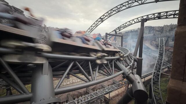 A super fast roller coaster with large, intertwined tracks. The car speeds past the camera.