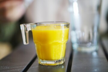 Close-up of a bright tropical juice in a clear glass, ready to drink
