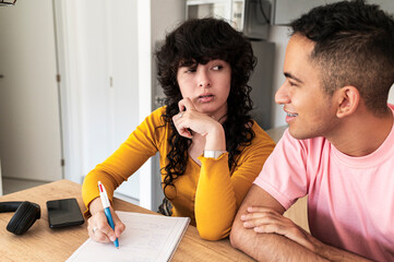 Focused student analyzing notes while friend offers support 