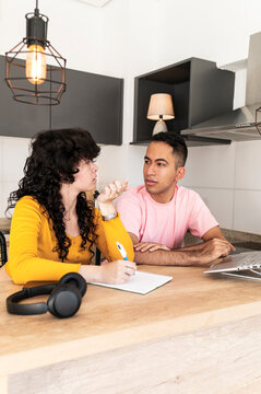 Confident friend guiding peer through learning moment at home