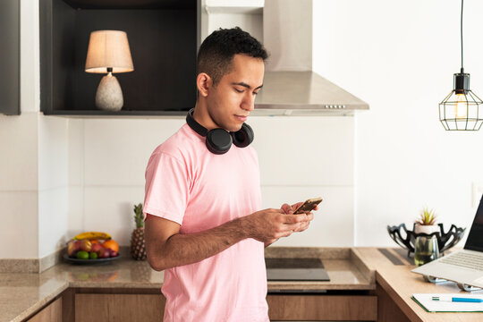 Focused latino professional reviewing phone updates in modern workspace