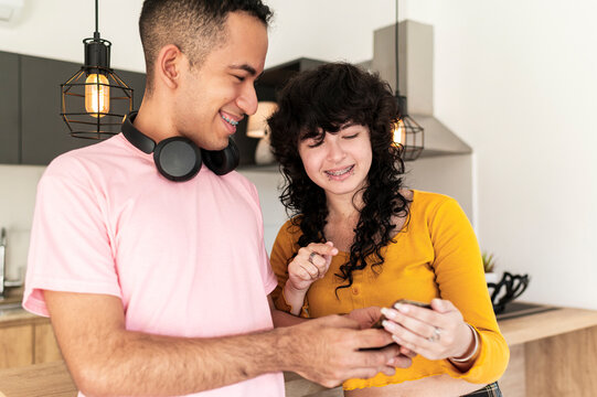 Latino friends sharing social media moment through smartphone content