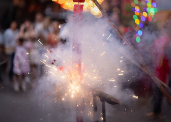 Exploding Chinese Firecrackers with Smoke and Sparks during Lunar New Year Celebration in Old Chinatown Street.