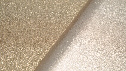 Displaying gold and champagne metallic glitter sheets in studio, catching light at diagonal seam
