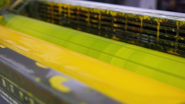 Yellow ink unit operating inside an offset industrial printing press