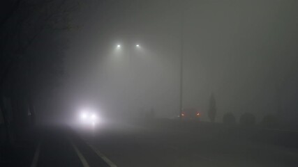 Traffic on foggy misty night road illuminated by street lights - Powered by Adobe
