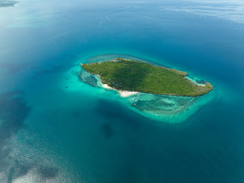 Small island with beach and blue sea. Virgin Island, Philippines.