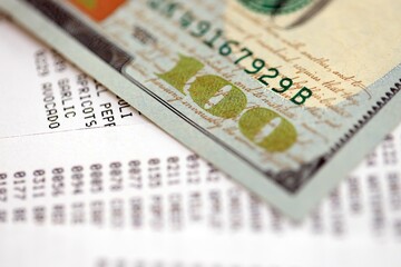 Money lose change after store visit with the store receipt. Supermarket check receipt and one hundred dollar bill close up