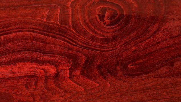 Showing red-stained wooden panel highlighting grain and knot on finished tabletop, lacquer finish