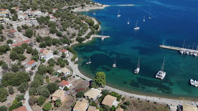 Kastos Island,Aerial Birdseye Scenic view,circle pan right above the town center and harbor,Beautiful sunny day.Lot of boats on crystal clear waters inside and outside of Harbor.