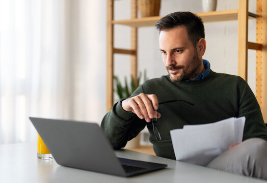 Man using smartphone and laptop computer for electronic banking, making reservation, online shopping - Powered by Adobe