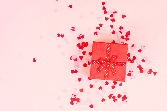 Valentines day festive background with pink hearts and red gift box - Powered by Adobe
