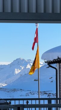 Swiss and uri canton flags waving in the alps