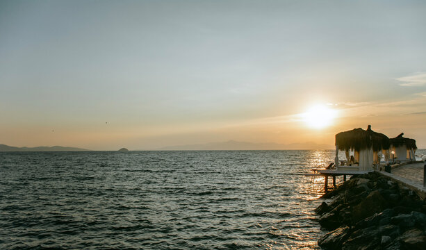 Sunbeds on a Wooden  Pier above the Sea with orange sunset sky .Summer Holiday in Turkey