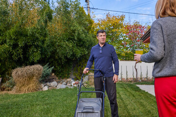 A middle-aged man and his wife work in the garden and do various maintenance activities.