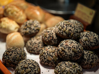 Assorted Breads with Sesame and Pumpkin Seed Toppings Displayed in a Bakery