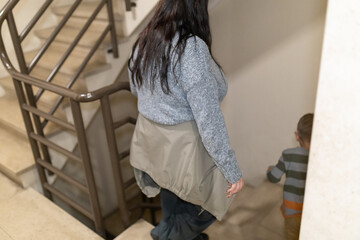 Fototapeta premium Mother and child descending building staircase together