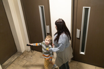 Boy holding flashlight with woman exploring dark corridor